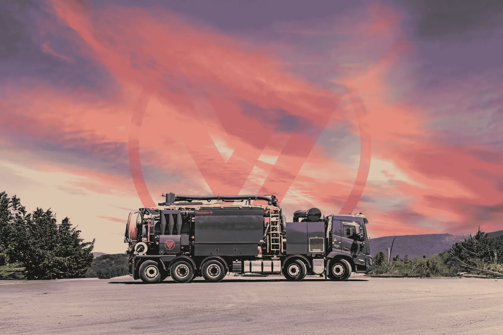 Vacvator vacuum truck parked under a dramatic pink sunset sky