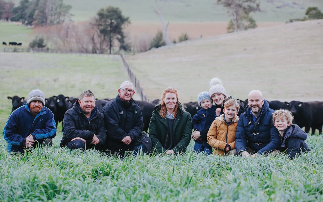 Gilmandyke Pastoral group portrait seated in a grassy paddock with cattle behind them