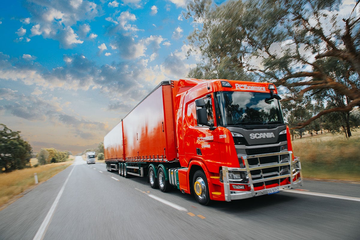 Red Ron Finemore Transport Scania truck and trailer driving on an open road