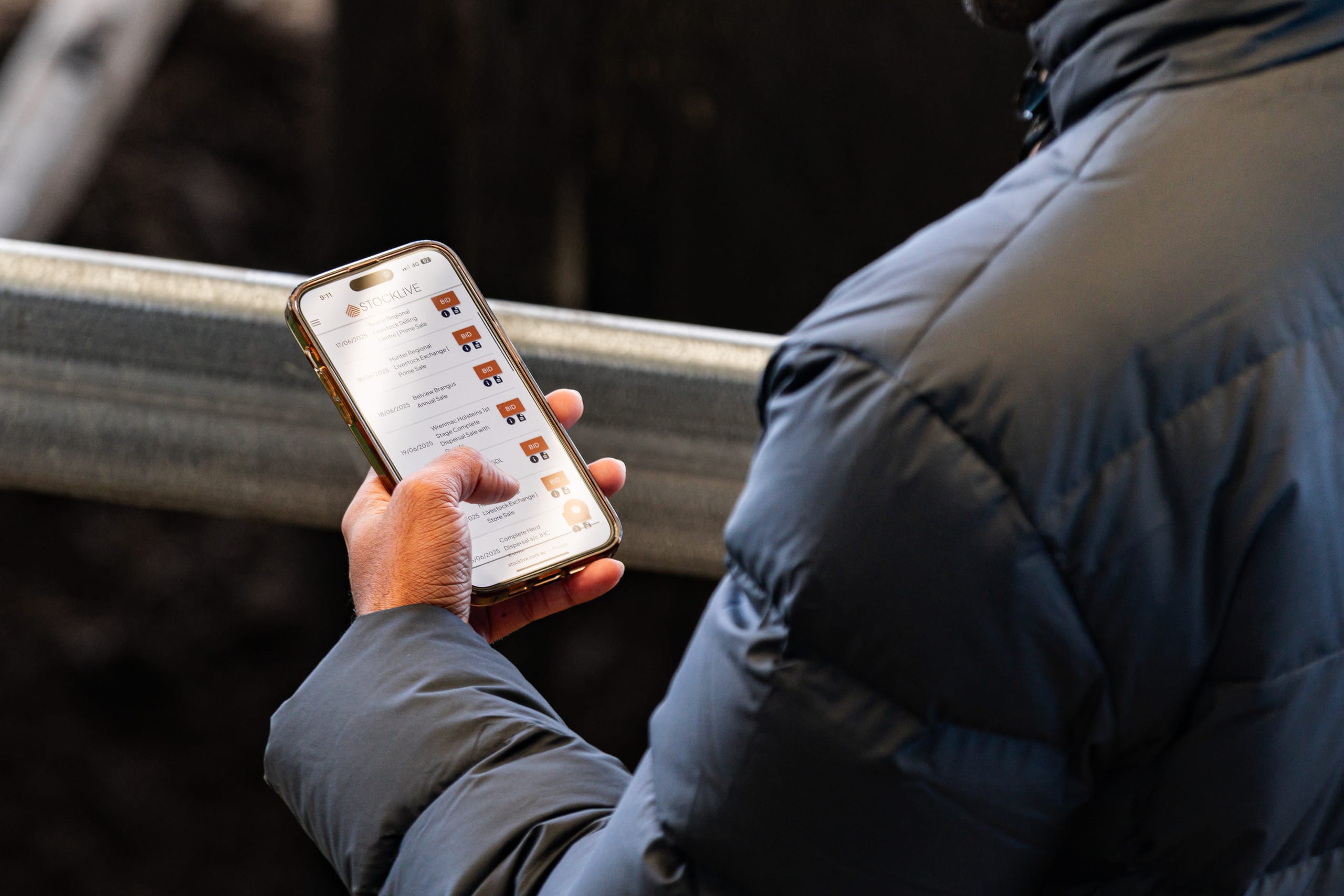 StockLive auctioneer in a hat taking bids inside a sale yard