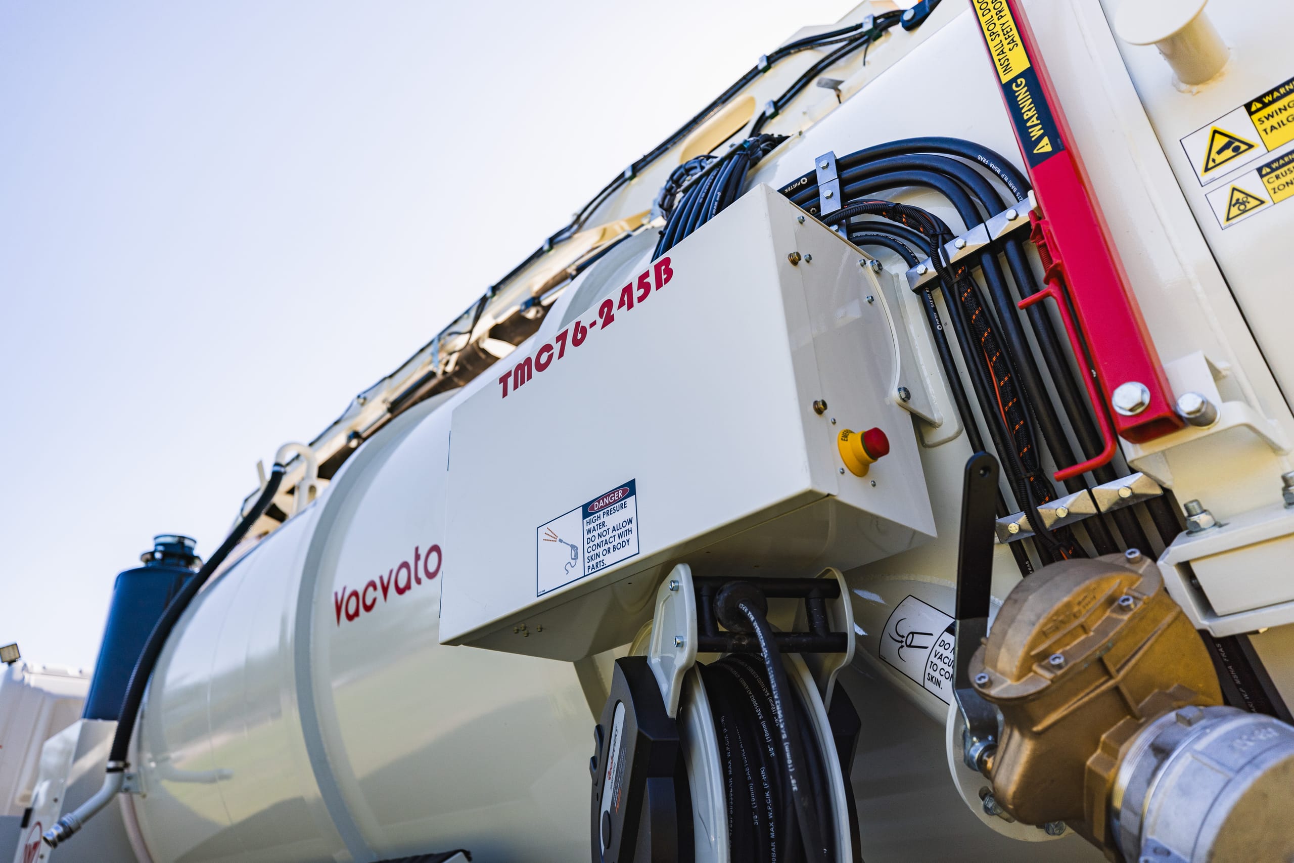 Close-up of a Vacvator vacuum truck tank, hose reels, and equipment fittings